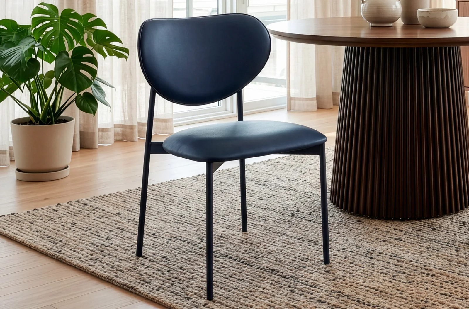 Silla de comedor Eva, símil piel negro en un salón